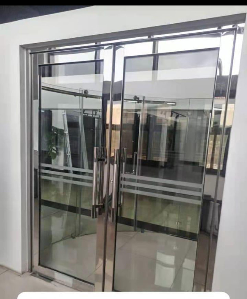 Toughened glass double swing door system with a stainless steel frame and handles