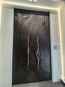 Modern luxury pivot entry door featuring a textured black finish and long, artistic golden handles